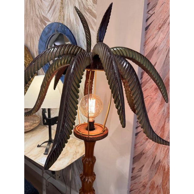 A rare carved wood floor lamp consisting of 15 alternate shapes palm leaves sitting on a carved palm tree style trunk &...