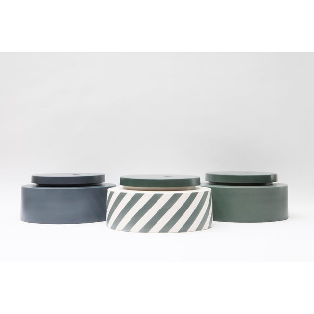 This striped or solid color ceramic vase features a wooden stopper and is a handmade unique piece. Stamped by Maker...