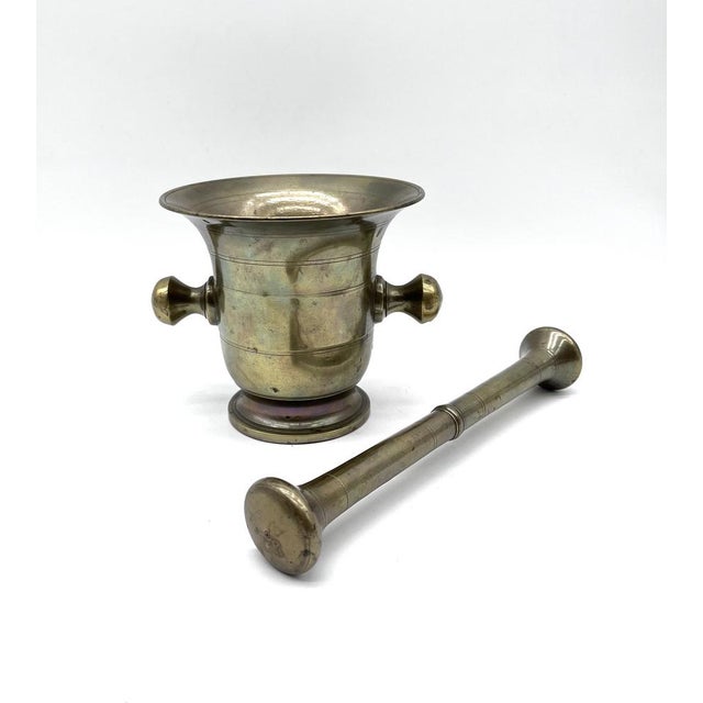 This heavy set, crafted from solid brass, impresses with its classic design featuring two side knob handles and finely...