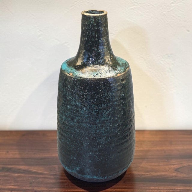 This Mid-Century-Modern Textured Reactive Glaze Pottery Bottle Vase in blue and green is a stunning piece of decorative...