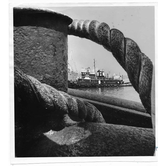 1982 b & w photo of a tugboat and docks at the port of Houston, Texas. Publication information is adhered and written on...