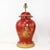 This vintage table lamp showcases an elegant temple jar silhouette, hand-painted in vivid red with intricate gold...