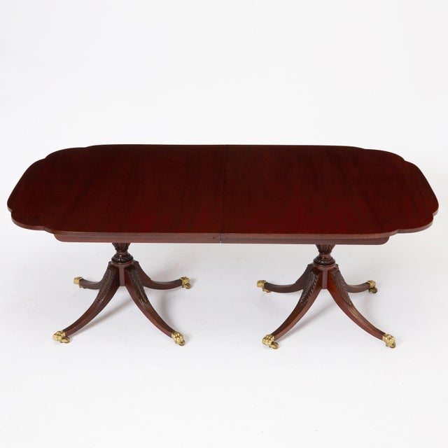 Elegant English George III style double-pedestal dining table, made in the early to mid-20th century and crafted in richly...