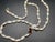 This elegant 14k gold jewelry set features a matching necklace and bracelet composed of iridescent, rice-shaped freshwater...