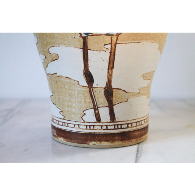 Vintage studio art pottery ceramic vase featuring a long-legged sandpiper wading bird against a neutral, earthy background...