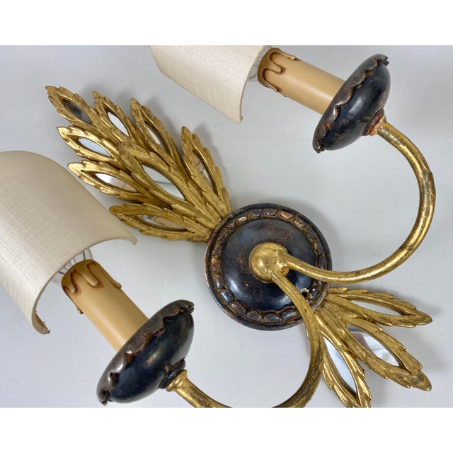 Vintage single sconce in the Empire style from Italy, circa 1950s. Made of wood and gilded metal with decorative trim and...