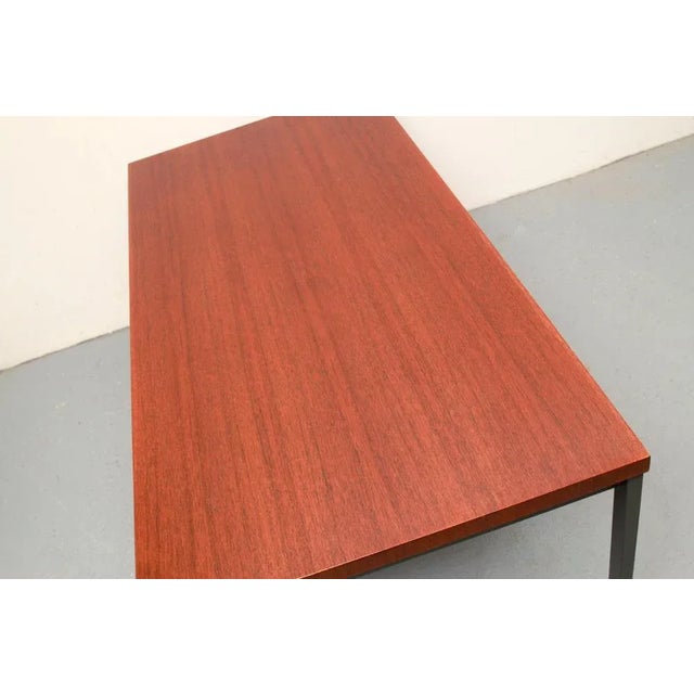 Simple 60s designer coffee table. Metal base, color anthracite. Table top veneered in teak. Beautiful condition with...