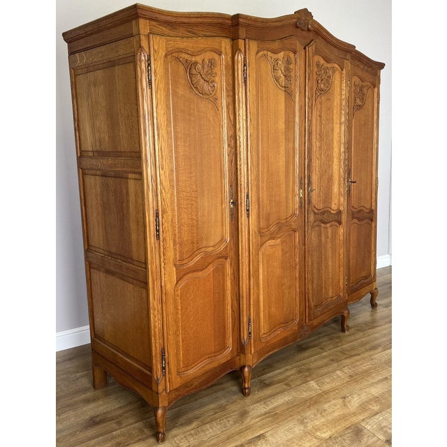 A beautifully presented Vintage French Louis wardrobe , featuring an elegant four-door design with a warm oak finish,...