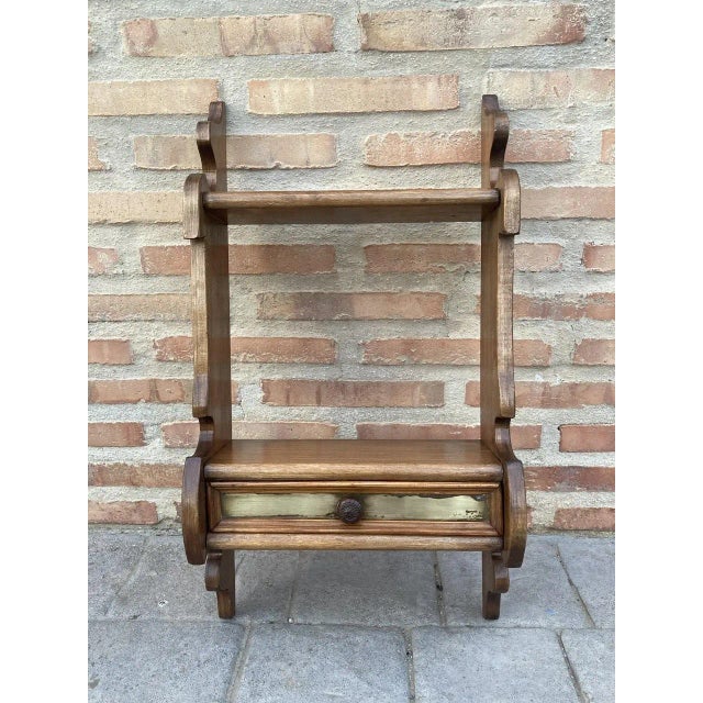 Small mid-century walnut wall shelf. It will need to be mounted with two screws to the wall. It has a shelf and a drawer...