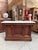 This antique bar counter has been fully restored. It features a marble top and a mahogany base with carved scrollwork. On...