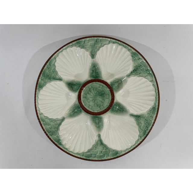 A charming French Faience Longchamp glazed majolica oyster plate with a lighter green basket weave background trimmed with...