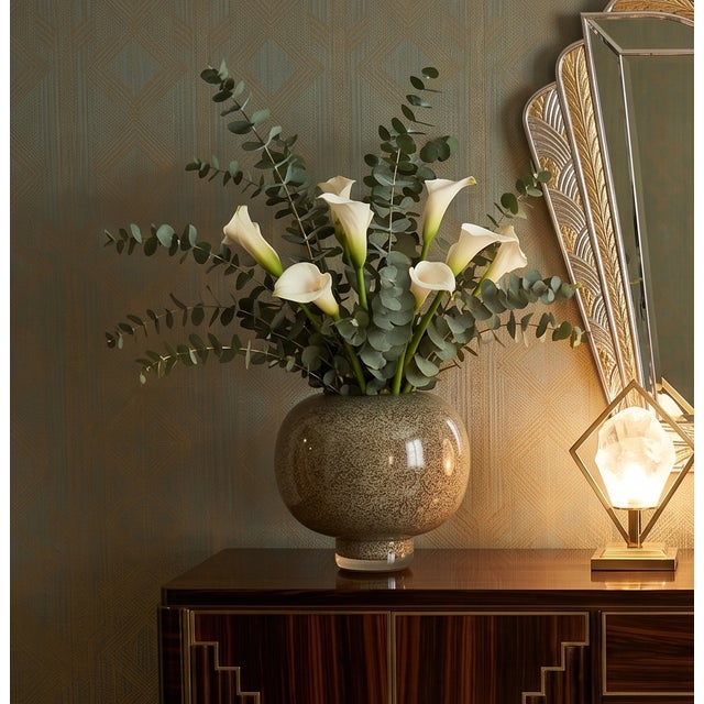 A mid-century modern studio art glass vase featuring a squat, spherical body with a thick, heavy clear cased base. The...