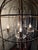 Elegant antique brass birdcage chandelier featuring a delicate open cage frame, scrolling candle-style arms, and sparkling...