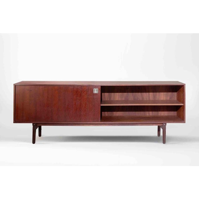 A refined Italian mid-century modern sideboard distinguished by its clean architectural lines, warm wood tones, and...