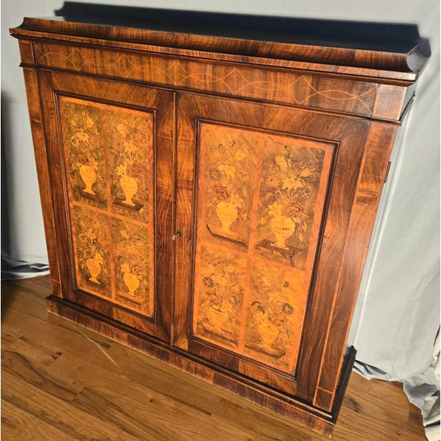 This is a records cabinet (not for vinyl records) made in the style of Louis XV. It has a high level of floral marquetry...