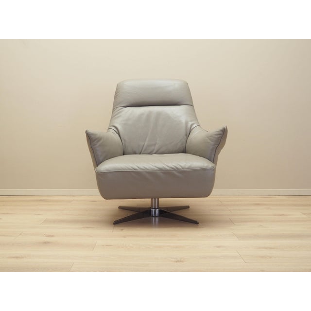 The swivel armchair was made in the 1990s, produced by the well-known Italian manufactory Natuzzi. The armchair is covered...