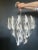 Clear acrylic “petals” with off white detailing cascade like a waterfall delicately down a chrome base chandelier. Six...