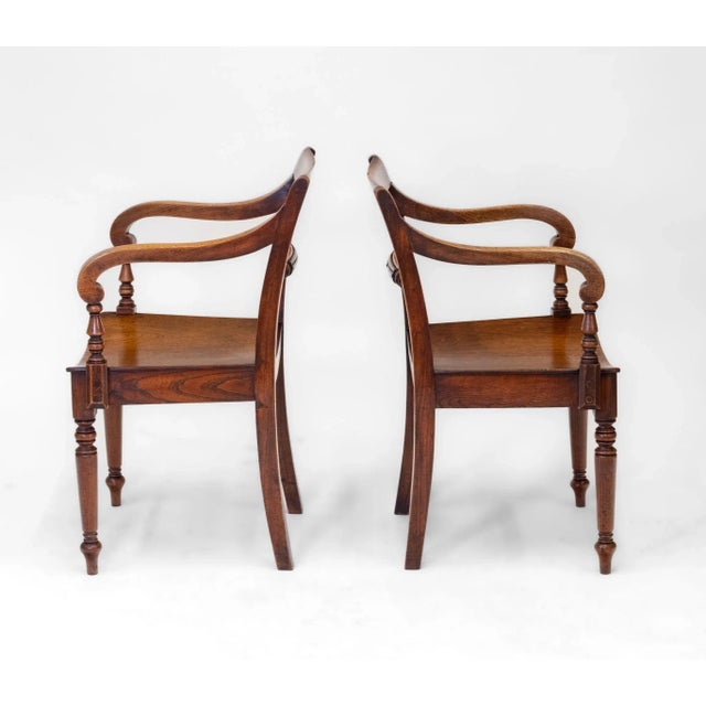A pair of English 19th century country elm armchairs. Circa 1860. The chairs are constructed in English elm with...