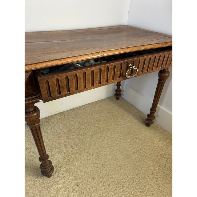 Beautifully carved French walnut writing table whose design features turned legs and a top in the Louis XIII style. Fluted...