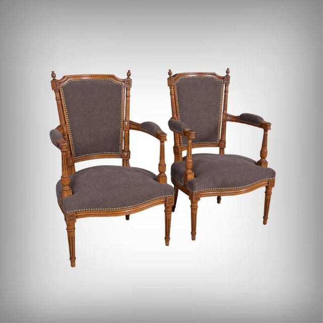 This elegant pair of stained beechwood armchairs, made in the 1950s, is faithfully inspired by the Louis XVI style. The...