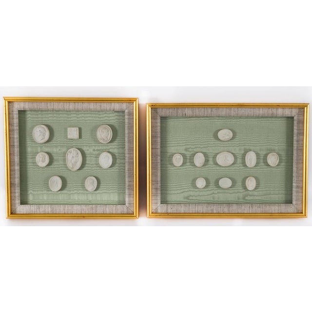 An elegant pair of giltwood glazed frames enclosing seventeen Grand Tour plaster intaglios dating from the early 19th...