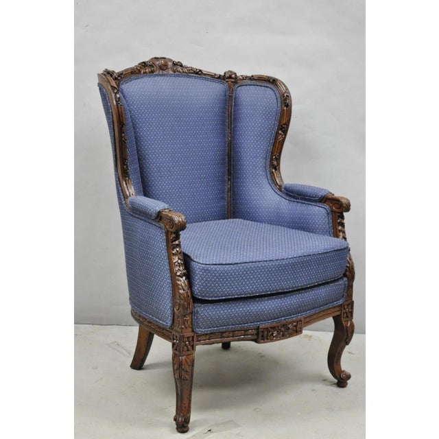Antique French Renaissance Louis XV Style Carved Walnut Wingback Arm Chair with Blue Fabric. Circa Early 20th Century....