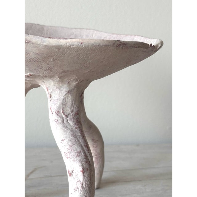 BOWL - RAÍZ terracotta with underglaze Three legs, each curved and hand-built, holding a shallow bowl above the surface....
