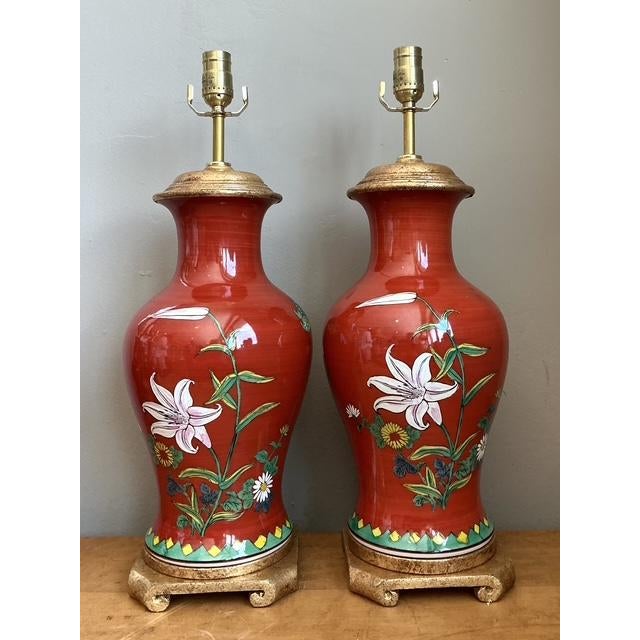 This exquisite pair of vintage table lamps features a vibrant coral-red glazed ceramic finish, beautifully adorned with...