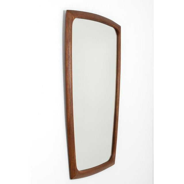 Danish teak mirror with an exceptionally beautiful shaped teak frame (symmetrical) with visible joints. In a good vintage...