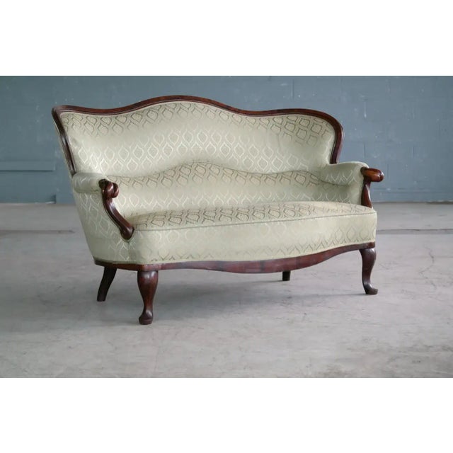 Elegant Rococo Revival style settee made from carved mahogany and made in Denmark around the 1860s. Sturdy and comfortable...