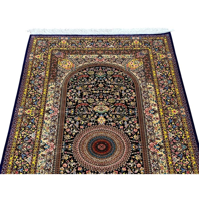 Persian Qum silk rug, machine-made in Iran. Measuring 3’2” x 6’6”, the rug features an elegant traditional Persian design...