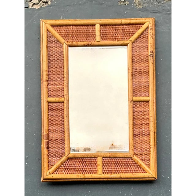 Infuse your living space with the relaxed elegance of this charming vintage Boho woven rattan mirror. Evoking a timeless...