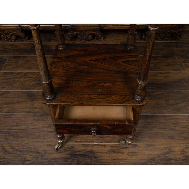 An English wooden trolley from the 19th century, with three shelves, low drawer and turned supports. Created in England...