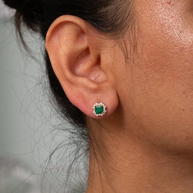 Two colombian emerald stones, emerald cut and 1 carats in total, sit at the centre of this pair of solid 14K yellow gold...