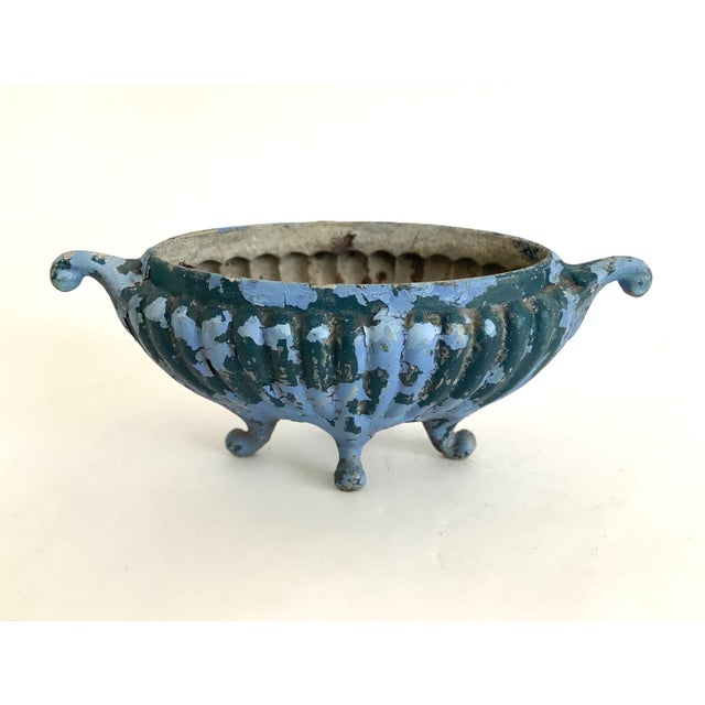 Antique French cast iron oblong footed urn with multiple layers of paint and aged patina. Drainage hole in the bottom.