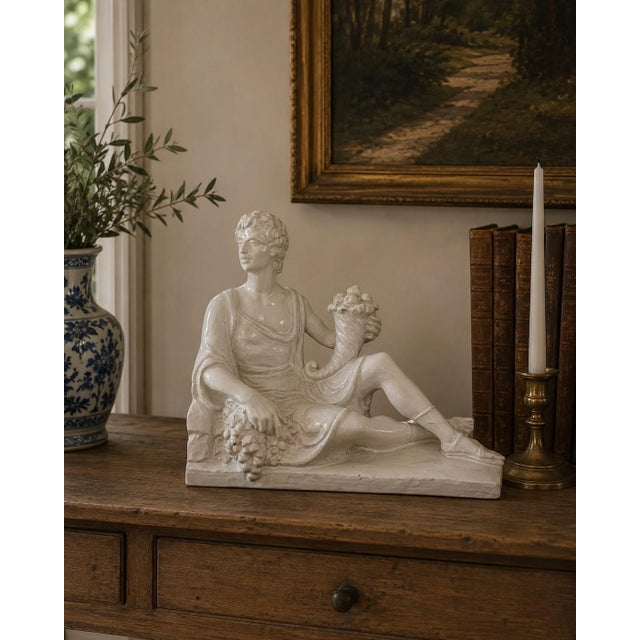 A handsome circa-1960s Italian porcelain sculpture depicting a classically draped reclining male figure holding a...