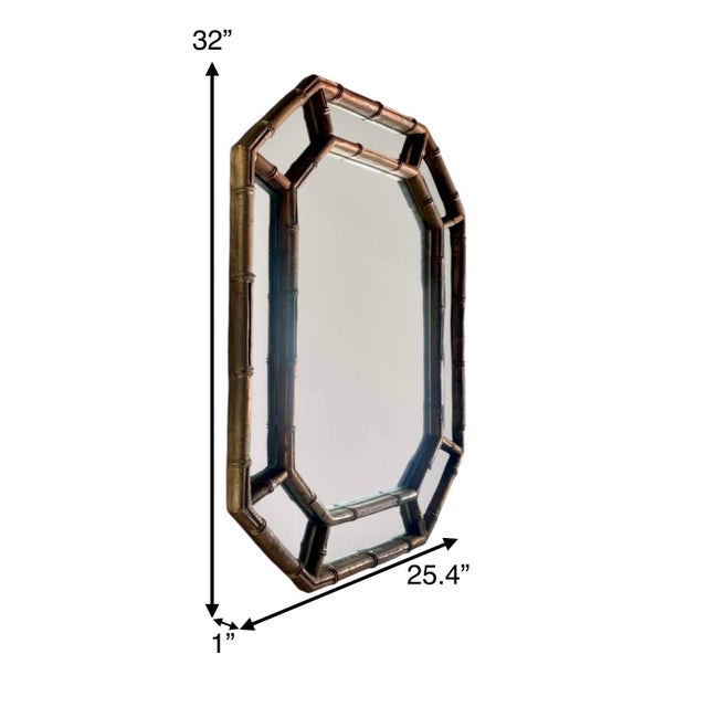 This vintage mirror made of heavy mixed composite material features a unique hexagonal shape with a faux bamboo gold gilt...