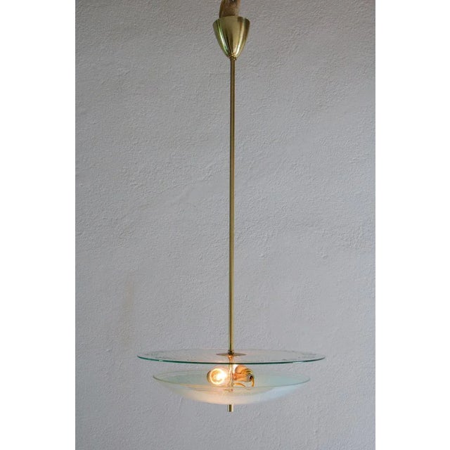 Italian mid-century modern double disc pendant lamp in turquoise color, 1950. Polished brass structure, curved silkscreen...