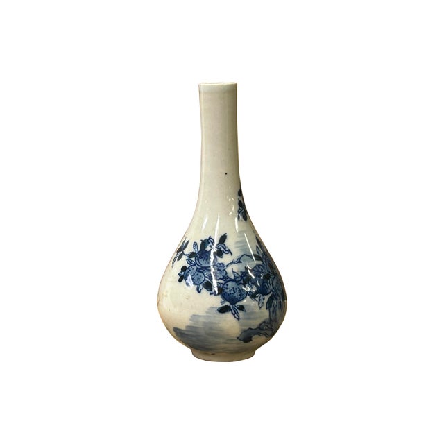 This delicate, miniature porcelain vase features a classic, elongated pear shape with a slender, upright neck. Rendered in...