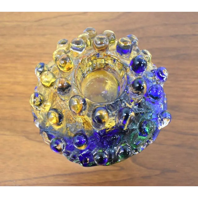 A beautifully blown glass candlestick holder made and signed by Goran Warff. Kosta Boda 7” wide. 7” deep. 7” tall.