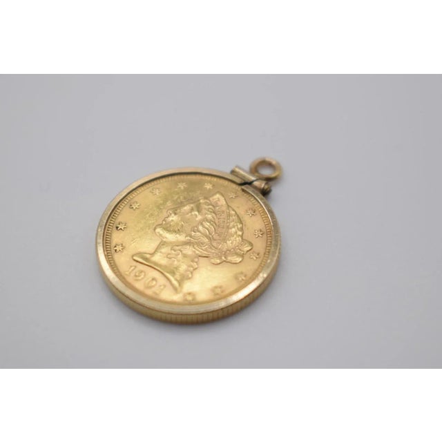 This is an 18k Gold 1901 Liberty five dollar coin. It is set into a bezel so it can be worn as a necklace.