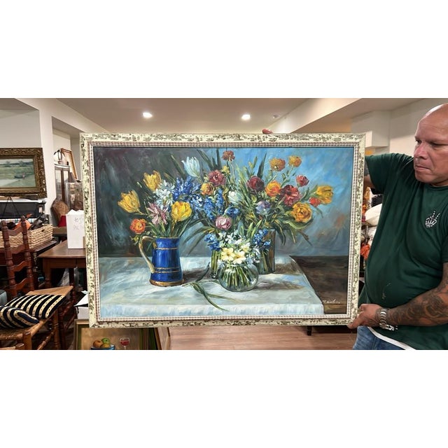An expansive oil painting depicting a vibrant arrangement of colorful spring blooms—including tulips and hyacinths—set in...