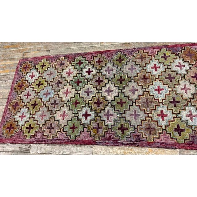 This antique American Hooked carpet is a beautiful testament to late-19th-century North American textile craftsmanship....
