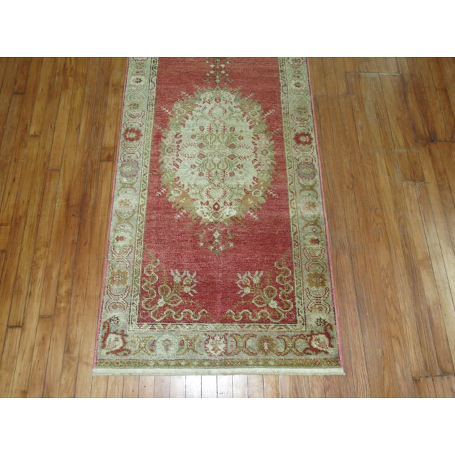 One of a kind, mid 20th-century Hand-knotted Turkish Wool Runner with 3 medallions on a soft red field. Professionally...