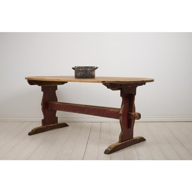 Antique Swedish dining table in folk art from the early 1800s. The table is a so called trestle table with a heavy table...