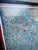 A striking vintage framed textile artwork featuring an intricate indigo geometric pattern accented with vibrant red and...