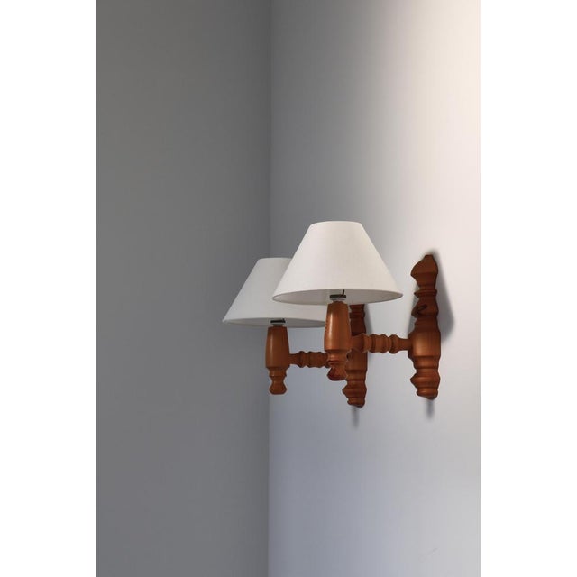 Set of large Scandinavian Modern wall sconces made in solid turned pinewood and mounted with new flax linen shades. Made...