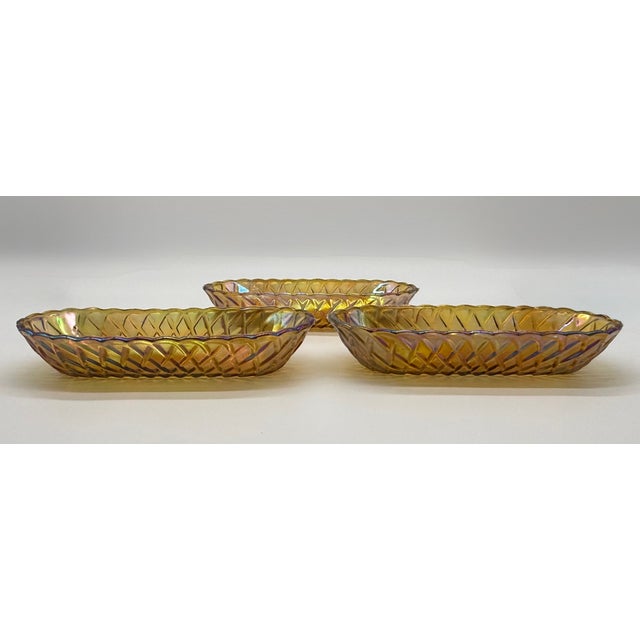 A beautiful early to mid-20th century set of amber carnival glass celery dishes featuring a classic elongated oval form...