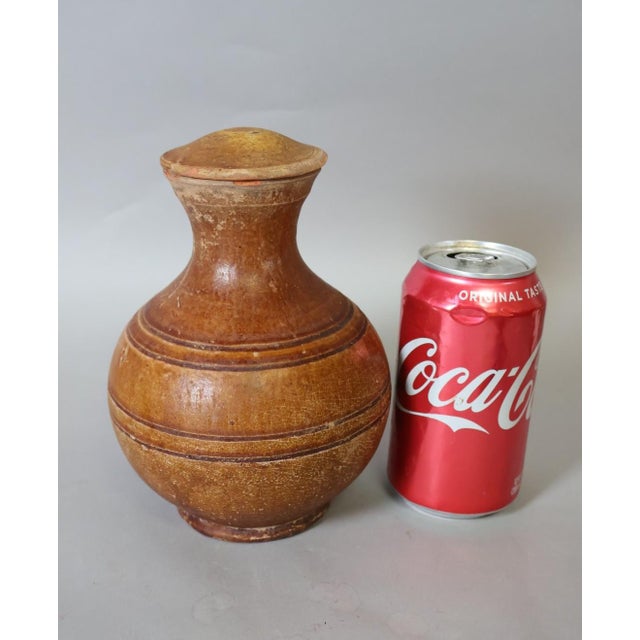 Ancient Chinese Han Dynasty pottery covered hu jar, dating to approximately 206 BCE–220 CE, with a warm amber-brown lead...