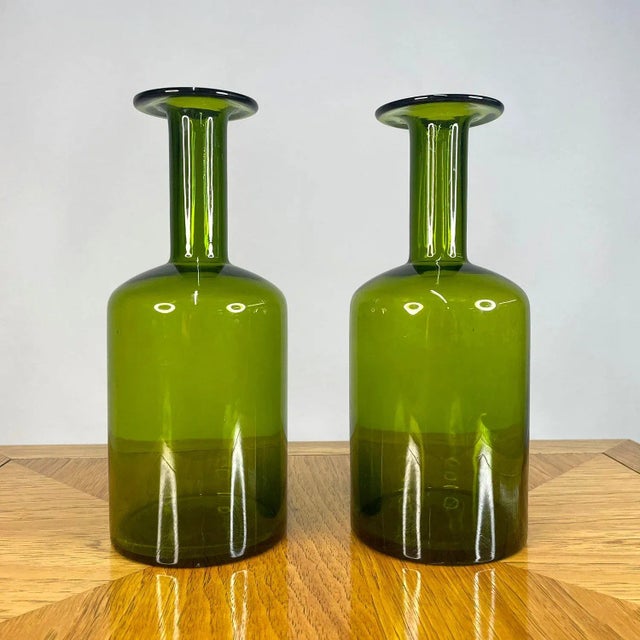 Handsome pair of Gulvvase glass vases designed by Otto Brauer for Holmgaard. The iconic bottle shaped vases were designed...